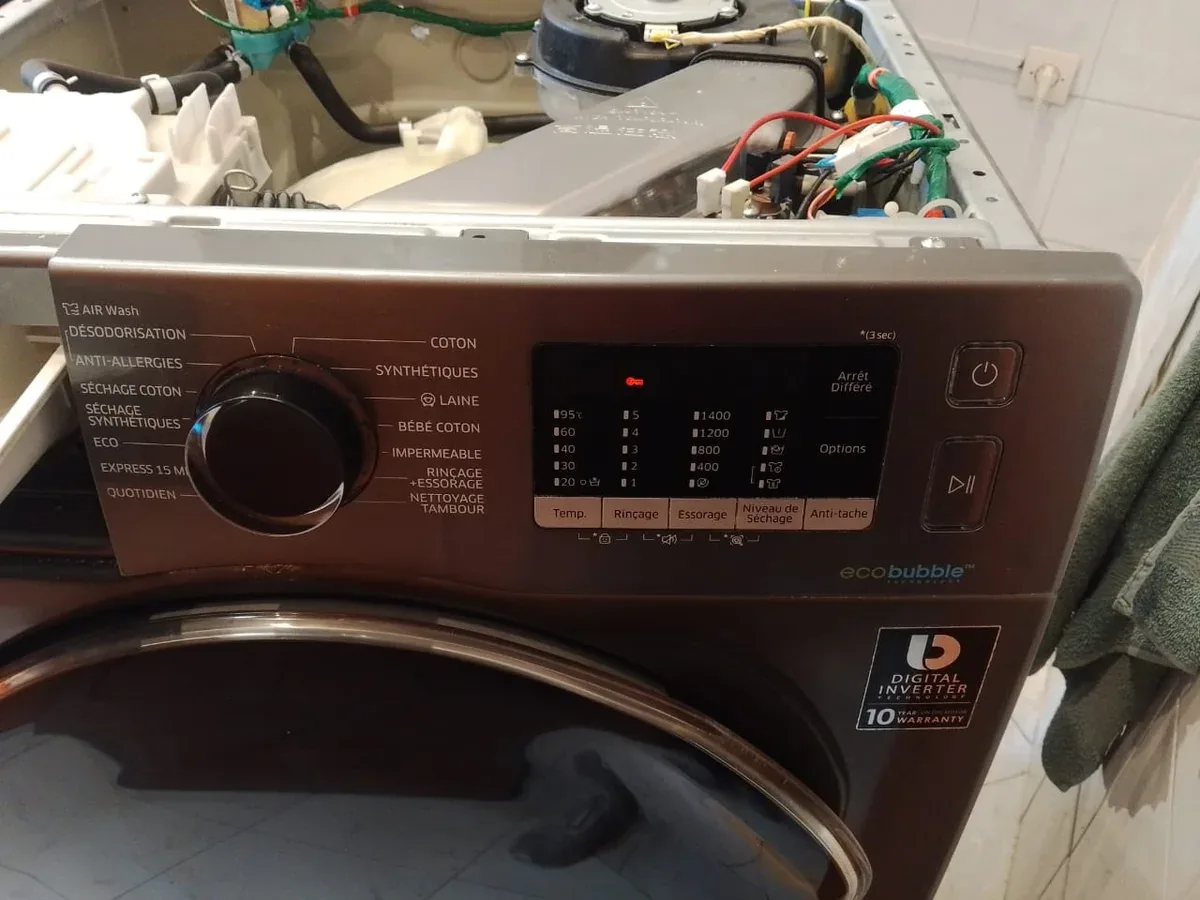 Bandeau de commande et partie supérieure ouverte d’un lave-linge